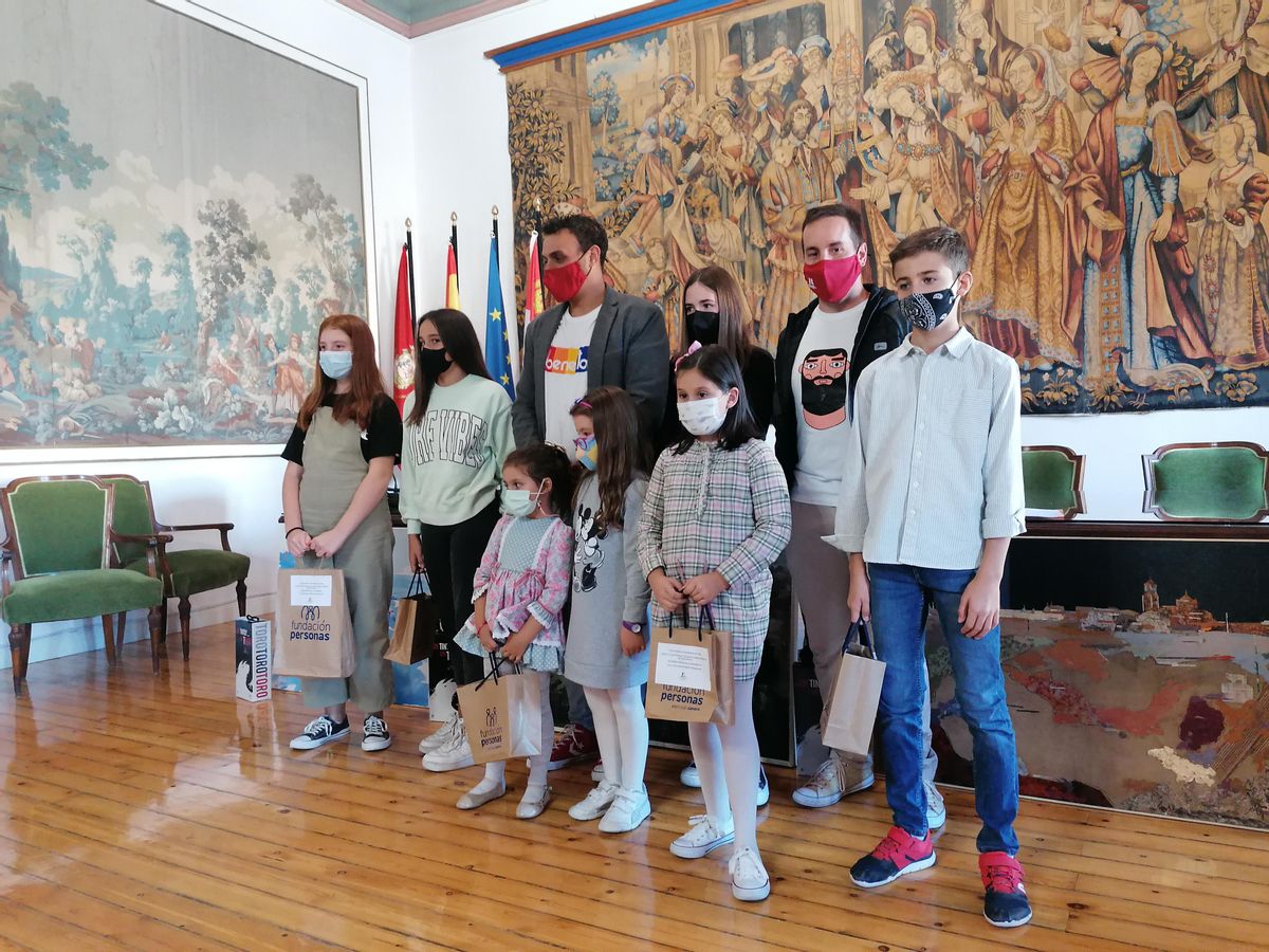 Autoridades locales posan con los niños ganadores del concurso literario y de dibujo sobre la vendimia