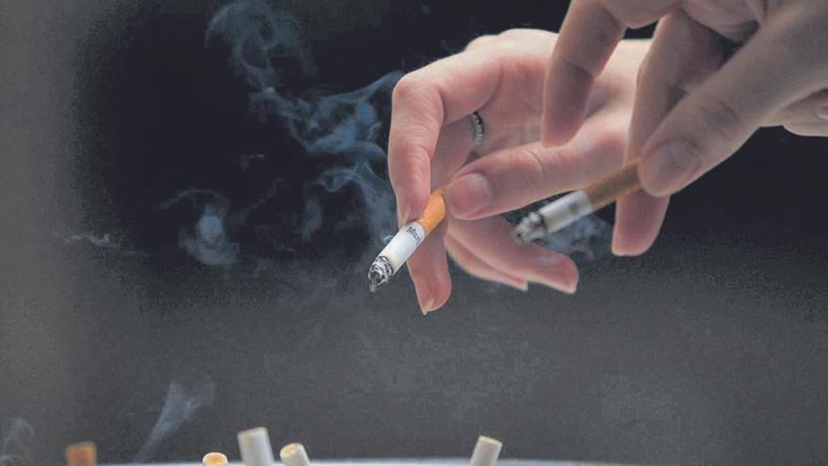 Dos fumadors treuen la cendra de les seves cigarretes. | MARCELO SAYAO