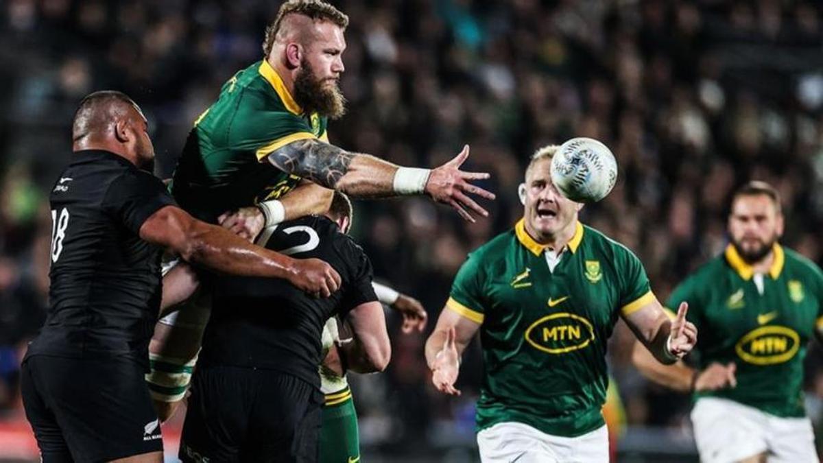El sudafricano Snyman descarga ante la defensa de dos jugadores neozelandeses.