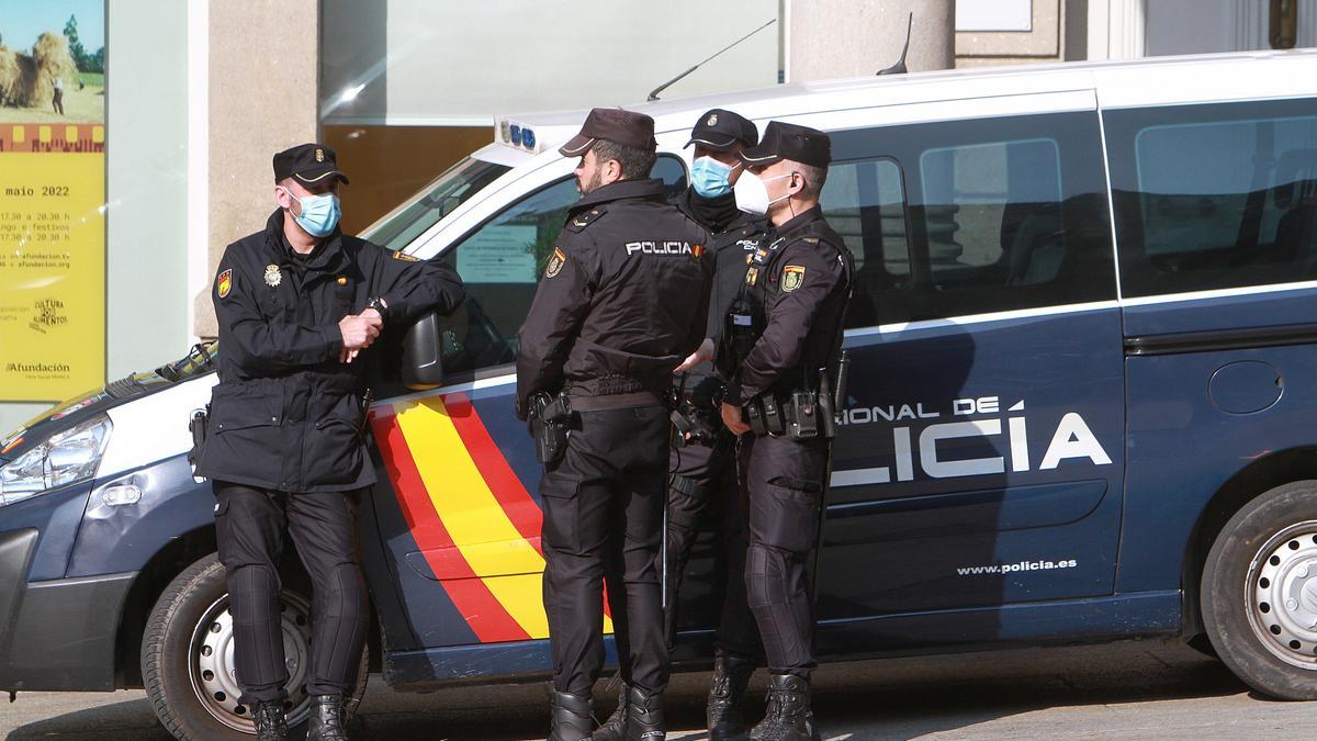 Policías nacionales de Ourense, junto a un vehículo.