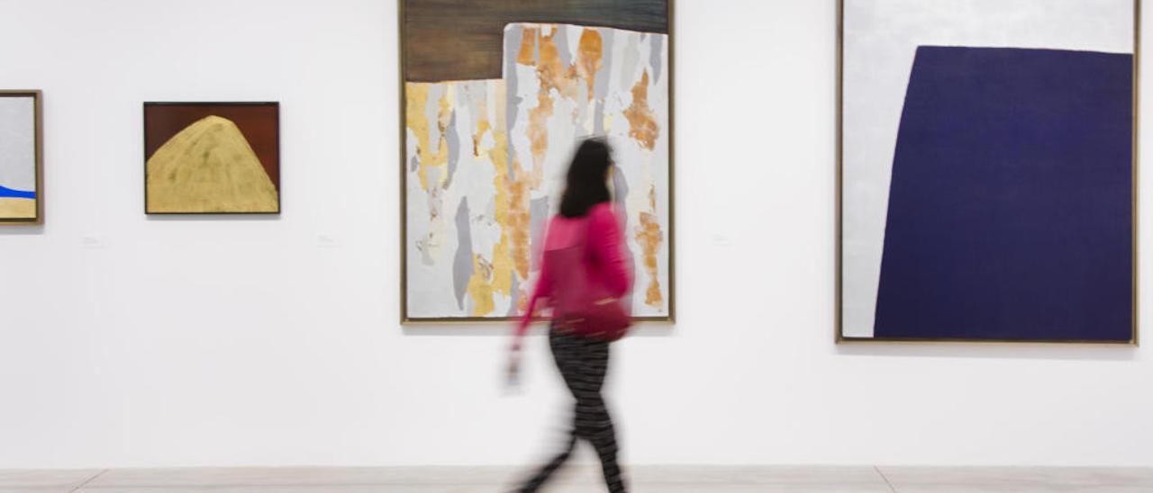 Una mujer camina por una de las salas del centro de arte Bombas Gens.