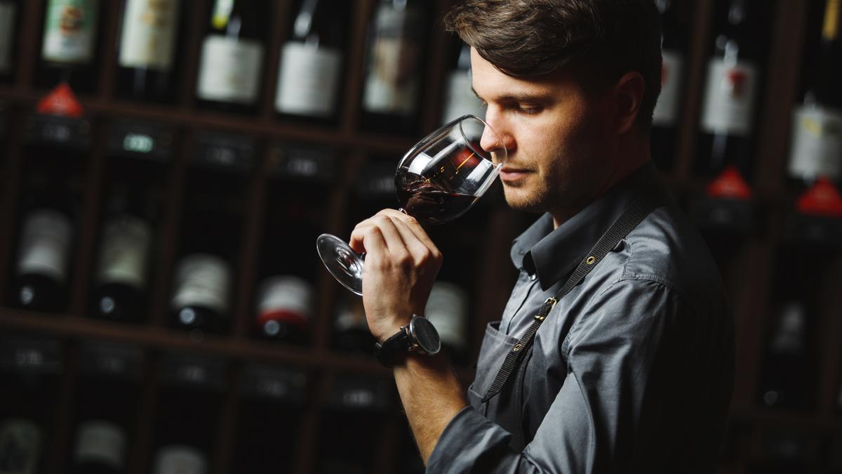 Un hombre cata una copa de vino.