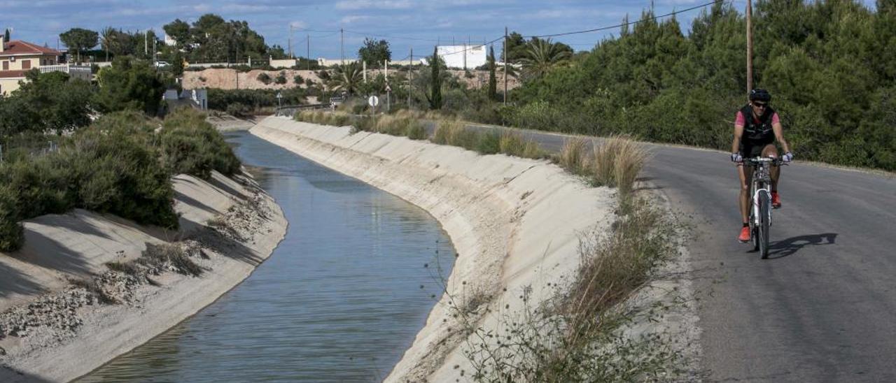 Un ciclista pasa junto a un canal del trasvase en el Campo de Elche.