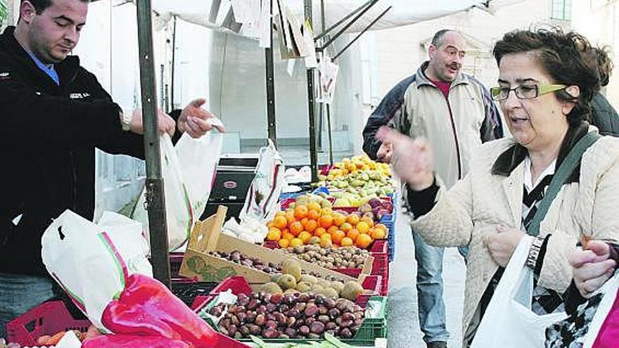 Iván Martínez, el portavoz del mercado, atiende a dos vecinas de la villa castropolense.