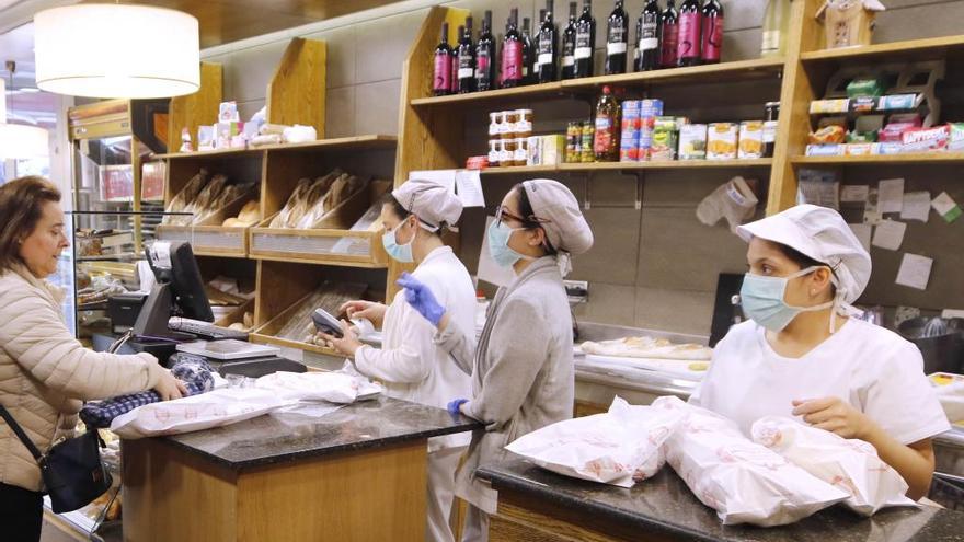 Empleadas de una panadería atienden con mascarilla. // Alba Villar