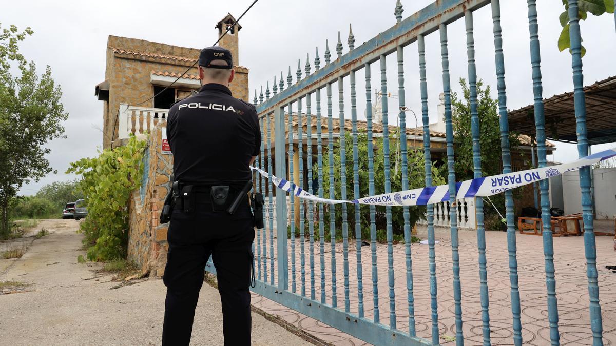 Un policía custodia la entrada de la vivienda incendiada el domingo de madrugada en Castelló.