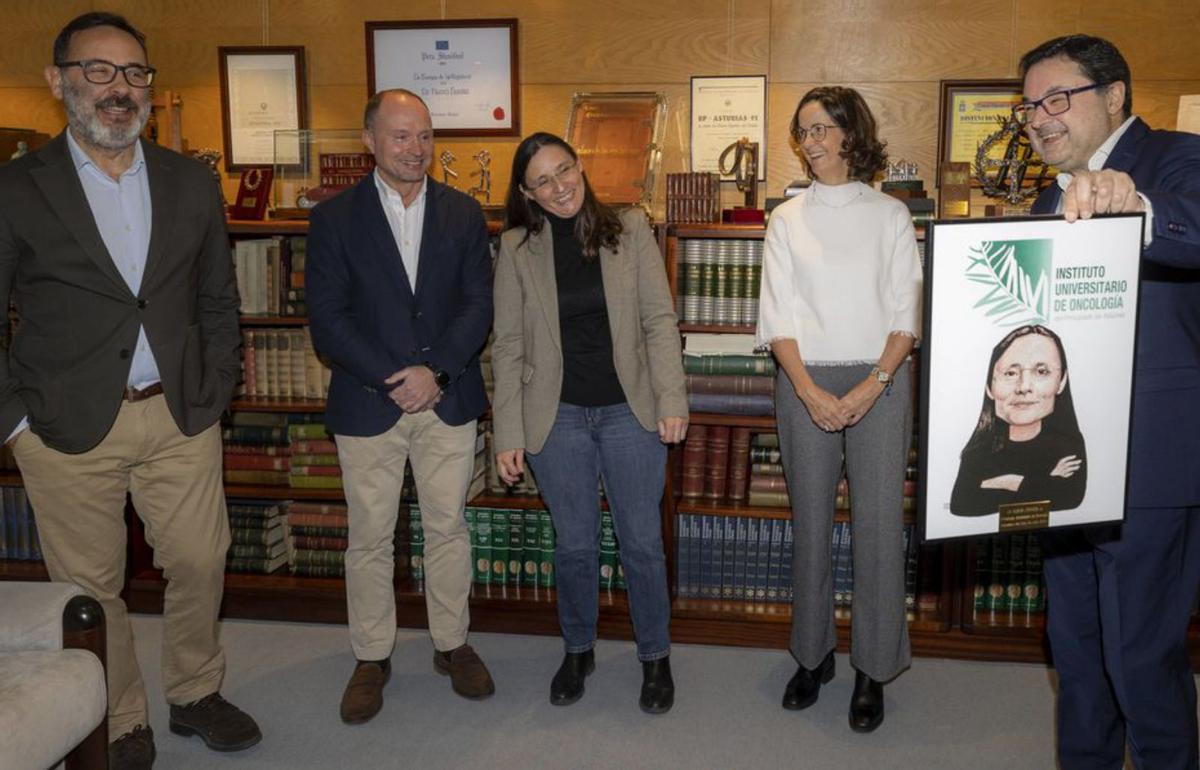 Gonzalo M. Peón muestra la caricatura de Ana Gutiérrez, directora del IUOPA, en presencia de la propia interesada y de Marcos Alonso, Mario F. Fraga y María Victoria G. Meana.