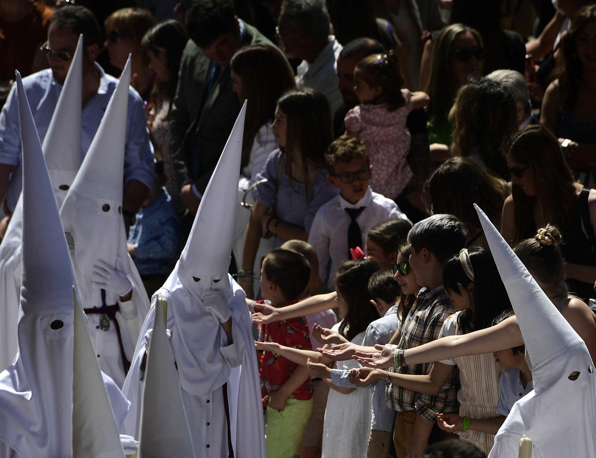 Penitentes de la hermandad de La Paz participan en la procesión del Domingo de Ramos en Sevilla