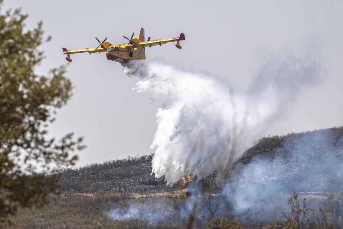Medios aéreos trabajan en la extinción del incendio declarado en la zona próxima a Casa de Miravete y Deleitosa, este domingo.