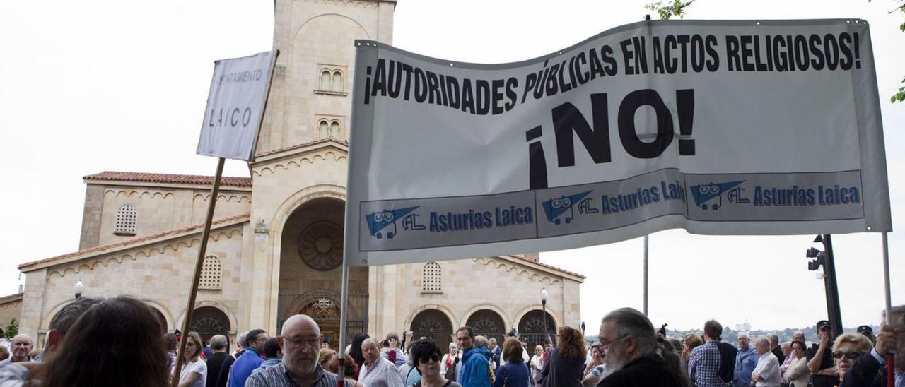 Una pancarta de Asturias Laica a las puertas de San Pedro exigiendo que las autoridades públicas no participen en actos religiosos. | Juan Plaza