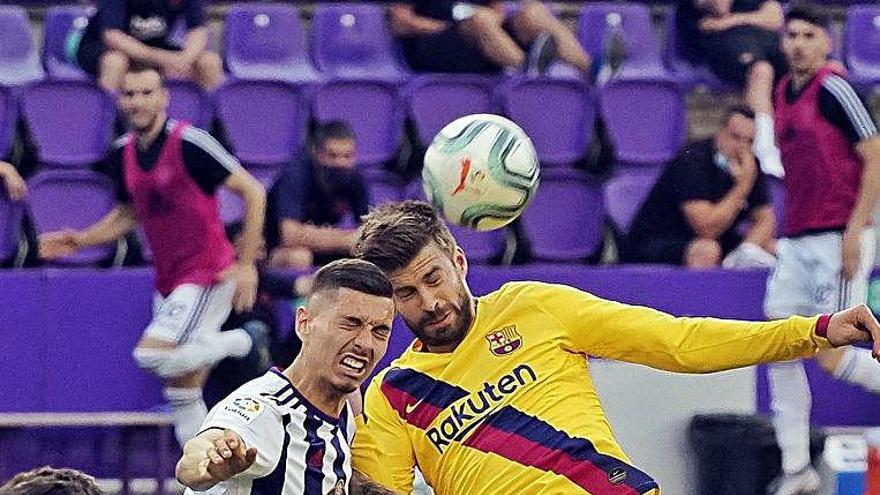 Gerard Piqué salta per aconseguir la pilota amb Javi Sánchez.