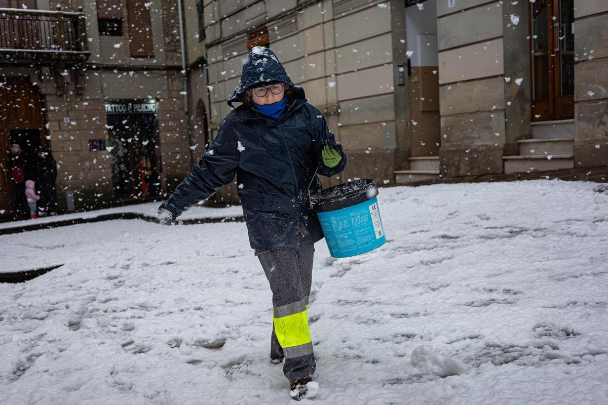 Una operaria del ayuntamiento de Solsona esparce sal por las calles.