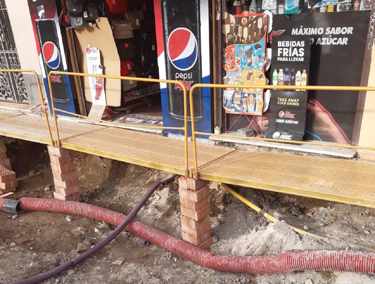 La pasarela de tablones, apoyada sobre ladrillos.
