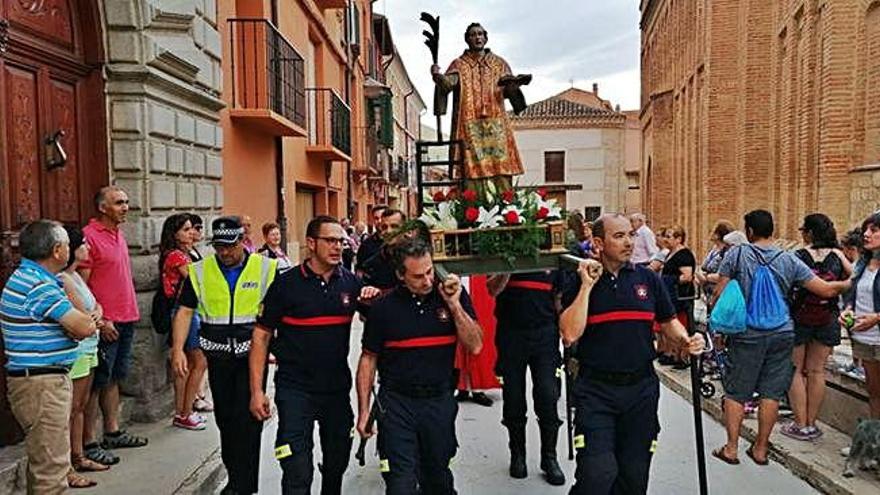 Bomberos de Toro portan a hombros la imagen de su patrón, San Lorenzo, durante la procesión por las calles de la ciudad.