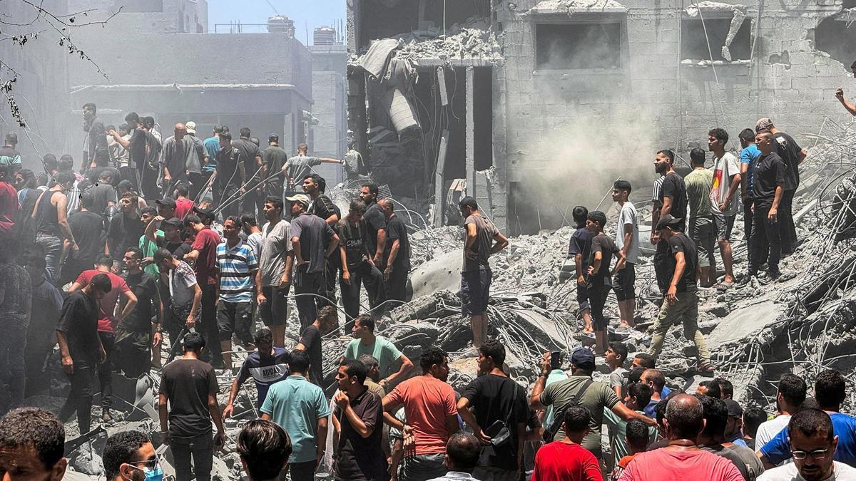 Ciudadanos palestinos buscan víctimas en el lugar de los ataques israelíes en el campamento de refugiados de Al Shati en la ciudad de Gaza.
