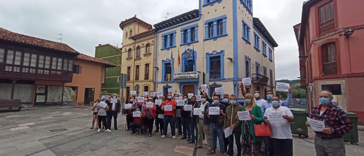 Los vendedores de textil y calzado del mercado de Grado, ayer, concentrados frente al Ayuntamiento.