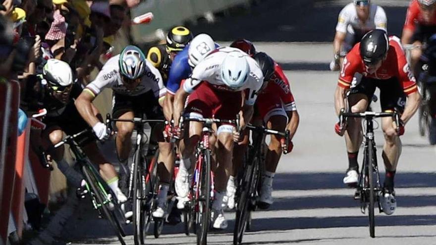 Cavendish, a la izquierda, se va contra las vallas al recibir el codazo de Sagan. // Yoan Valat