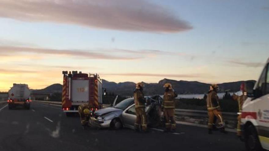 Bomberos junto al vehículo donde viajaba la niña fallecida.