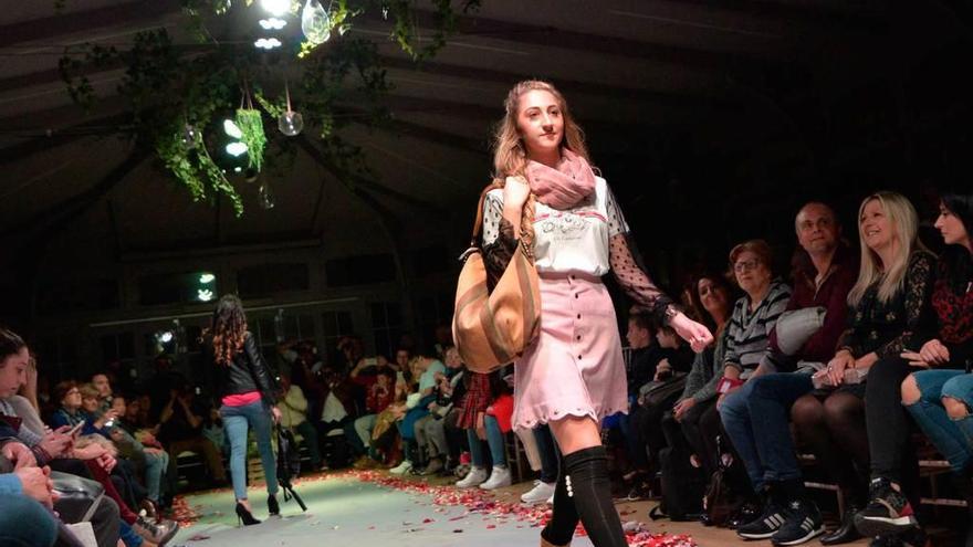 Dos modelos exhiben ropa de moda en el desfile de ayer.