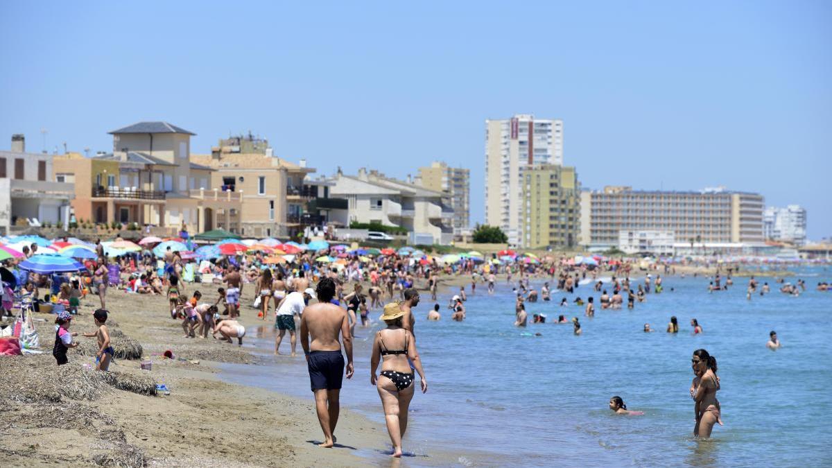 Bañistas disfrutan de una playa de La Manga en el primer día del verano.