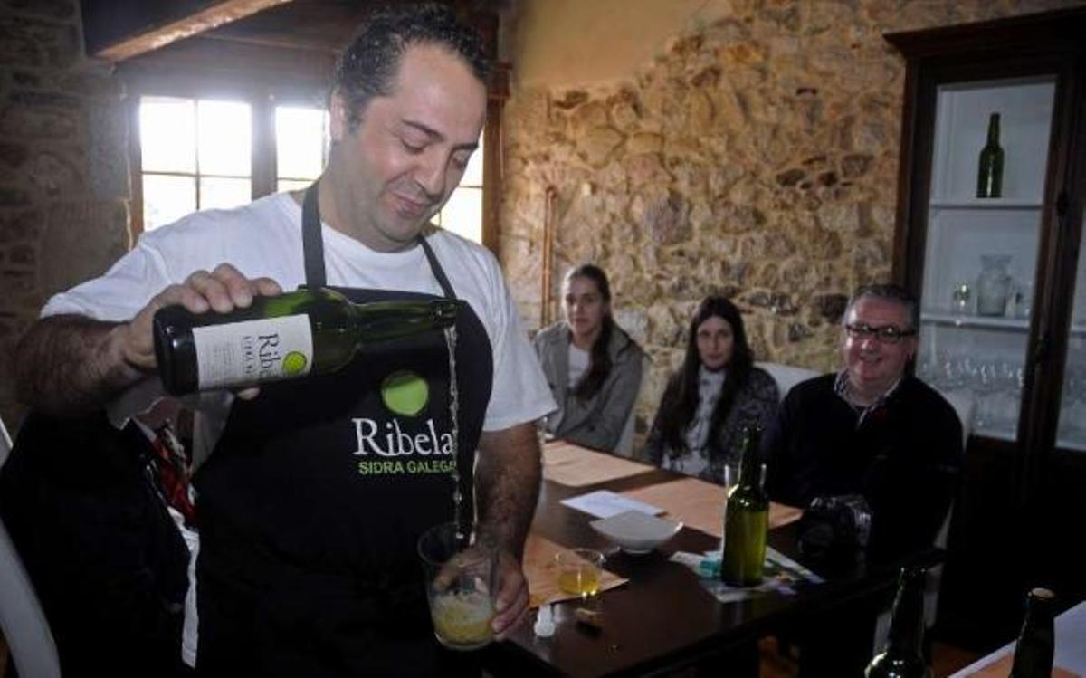 Jesús Armenteros, ayer, sirviendo sidra en la sede de Lagar de Ribela.  // Bernabé / Javier Lalín