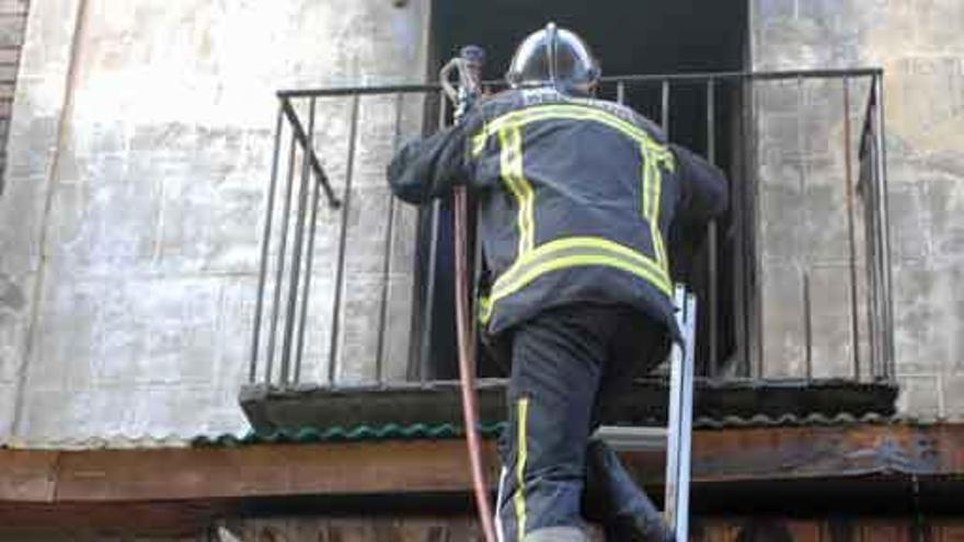 Los bomberos acceden a la primera planta del edificio durante el incendio.