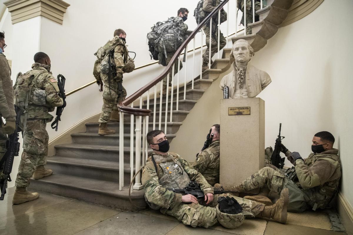 Soldados de la Guardia Nacional se distribuyen junto a un busto de George Washington en el interior del Capitolio