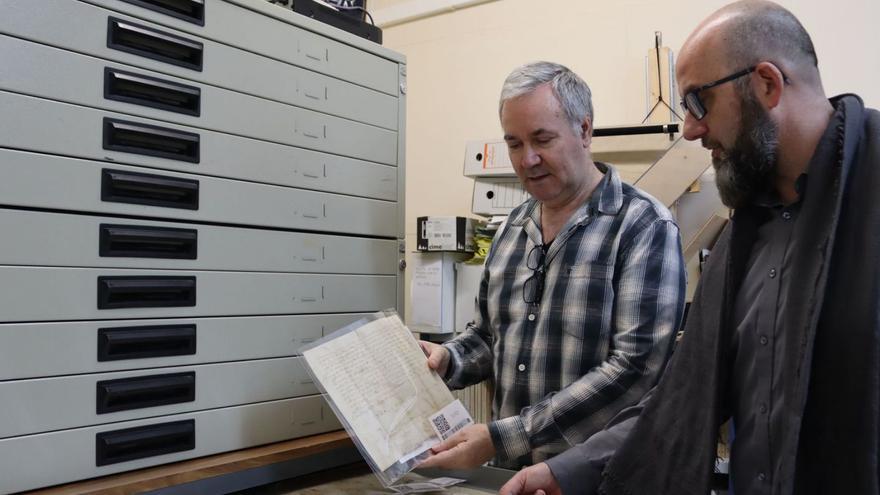 L’encarregat de l’arxiu, José Miguel Moliner, mostra al regidor Santi Cortells un dels antics documents. | MEDITERRÁNEO