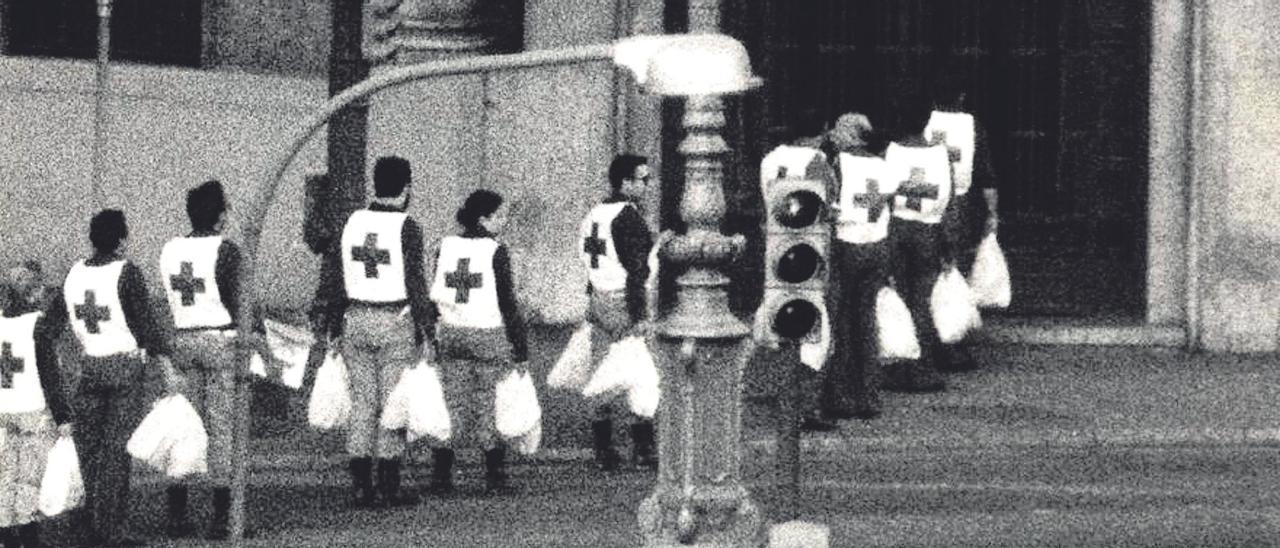 Miembros de la Cruz Roja llevan bolsas con comida a los rehenes y atracadores que siguen dentro del banco.