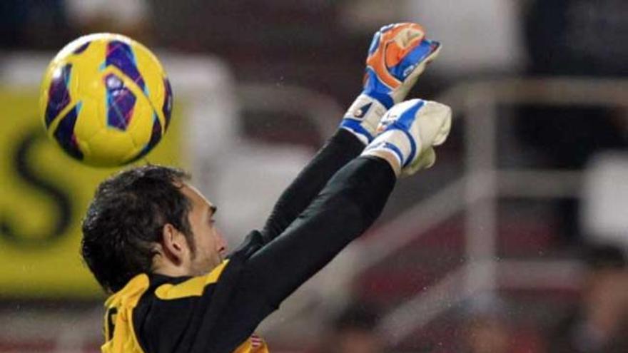 Diego López sale a despejar de puños un balón al área.