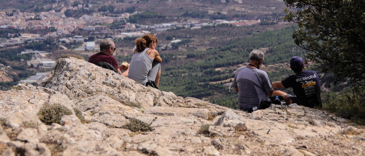 Excursionistas en la Font Roja contemplando una panorámica de Alcoy.