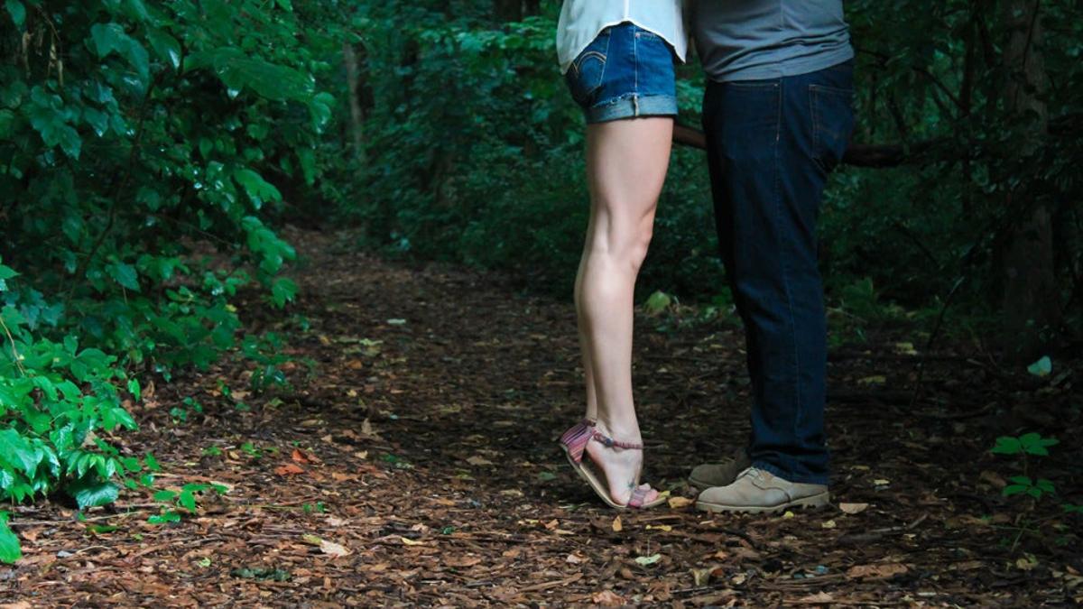Beso anónimo en un bosque
