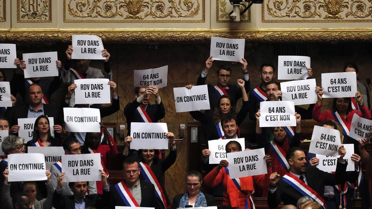 Membres de l'esquerra francesa al Parlament aixequen pancartes després del resultat de la moció de censura