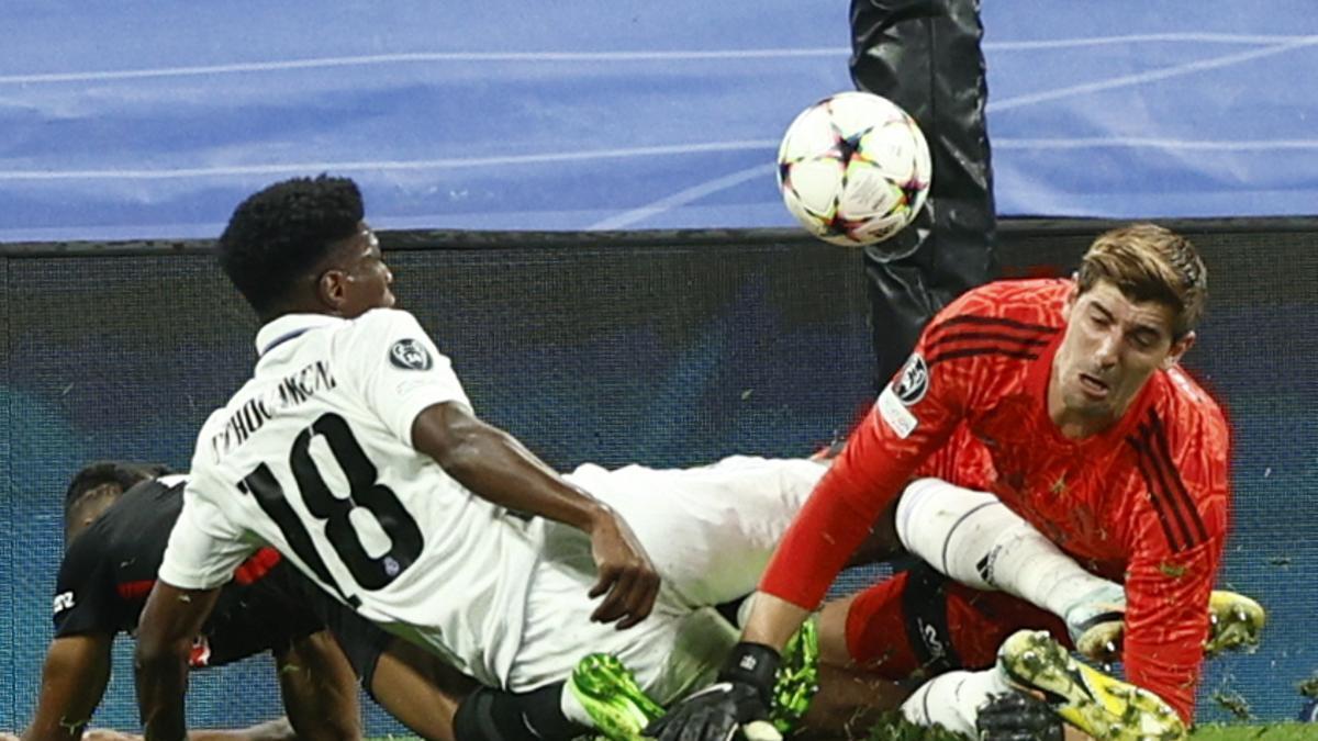 Thibaut Courtois y Aurelien Tchouameni pelean un balón con Christopher Nkunku, en un partido de Champions del Real Madrid.