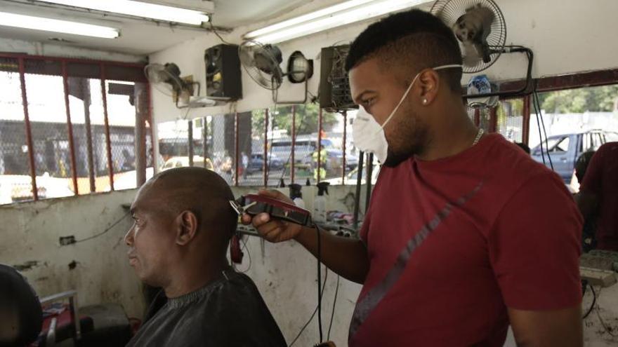 Un peluquero utiliza mascarilla por el coronavirus en Panamá.