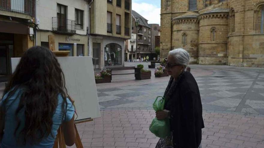 Una mujer se interesa por el trabajo de una joven, que ganó en categoría juvenil.