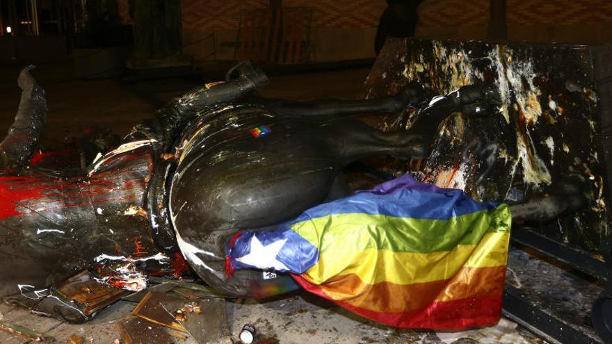 Unos jóvenes han tumbado la estatua de Franco.