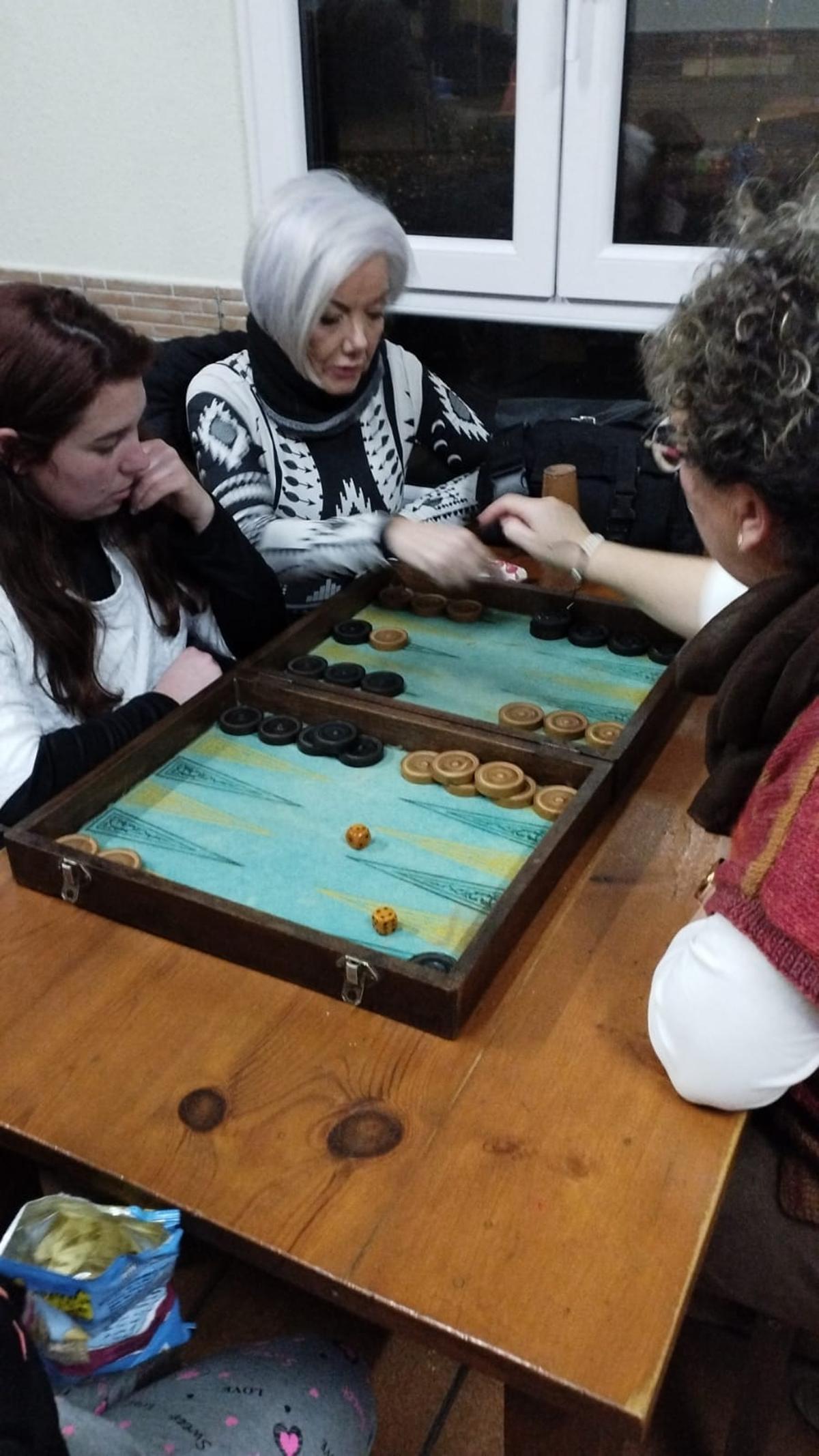 Tres vecinas, jugando a backgammon, en el bar La Casina de Valdredo.