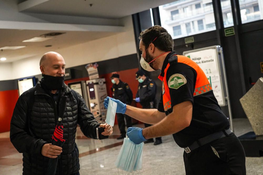 Reparto de mascarillas en la estación de metro del Perchel y en la estación de Cercanías María Zambrano, este lunes con el reinicio de la actividad laboral no esencial.