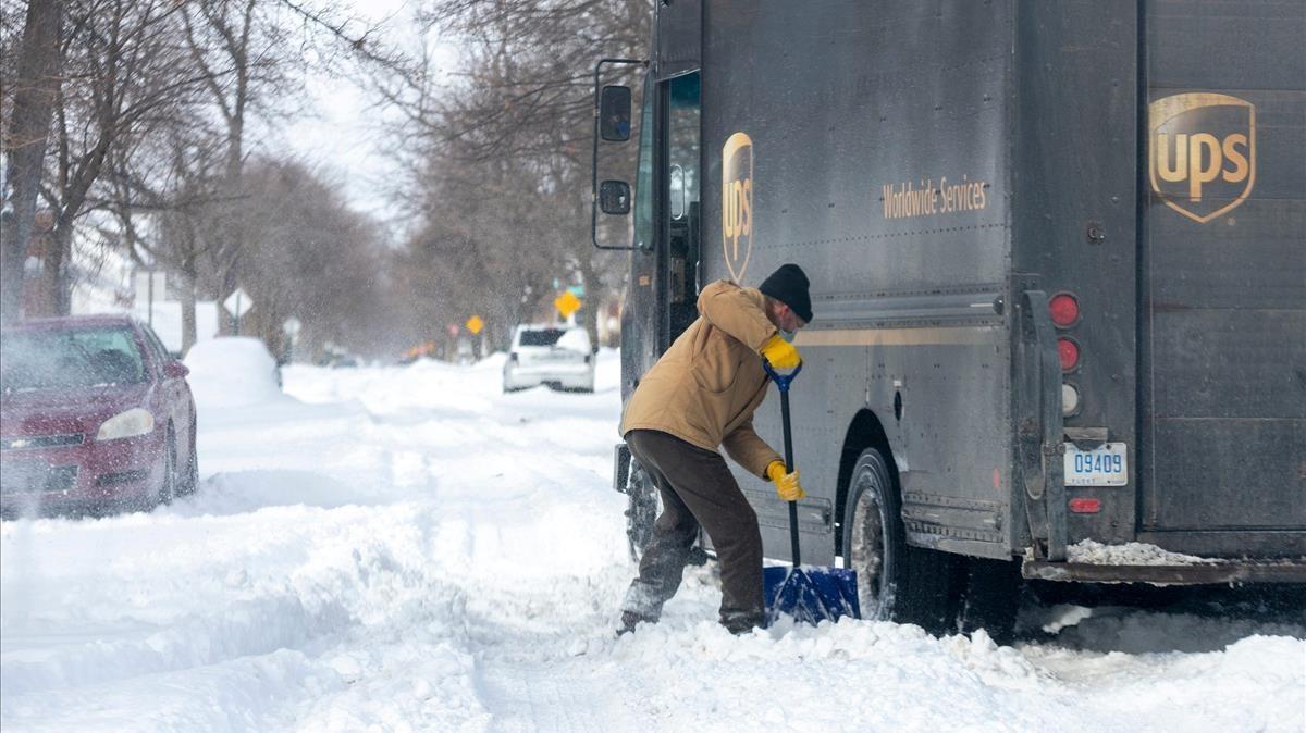 Mike Charnesky trata de extraer la nieve que frena su camión en Detroit, Michigan.