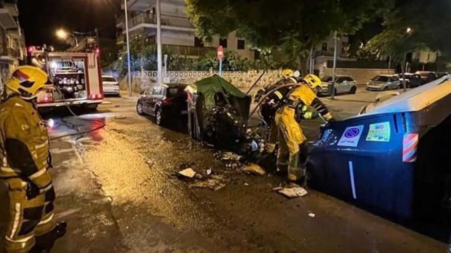 Bomberos, junto a los contenedores quemados.