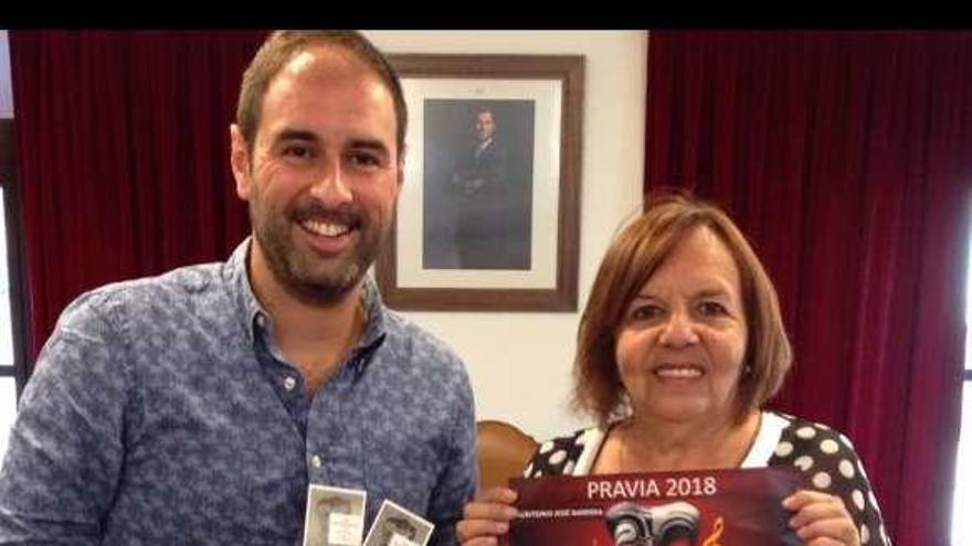 El alcalde de Pravia, David Álvarez, sostiene los abonos de regalo y la edil de Cultura, Valle Iturrate, el cartel con la programación, ayer, en Pravia.