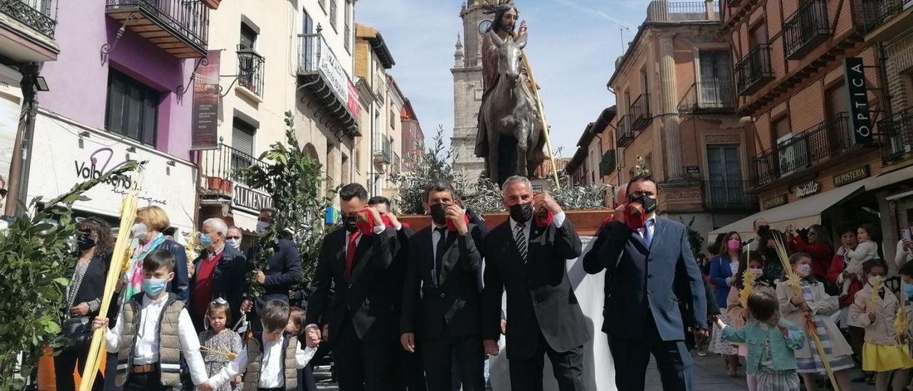 Los cargadores portan a hombros la imagen de “La Borriquilla” a su paso por la Puerta del Mercado. | M. J. C.