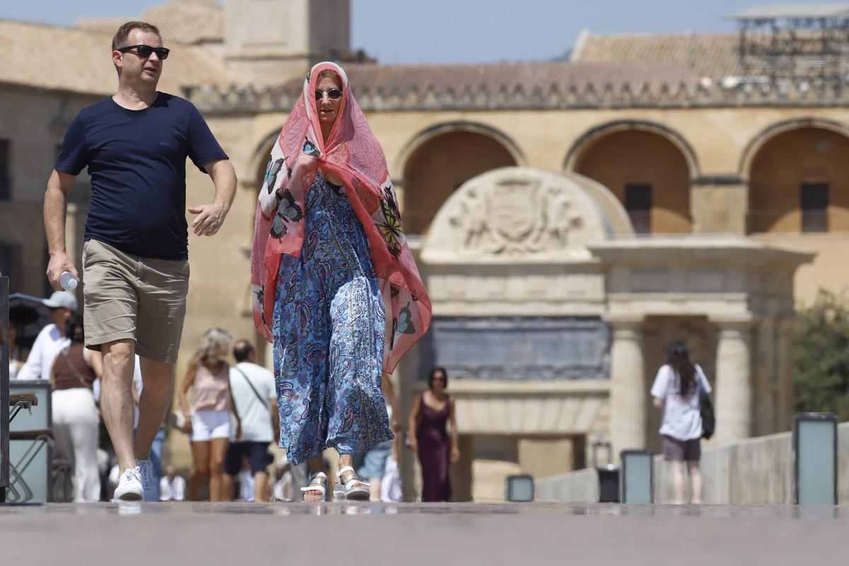 Turistas se protegen del calor en el Puente Romano.