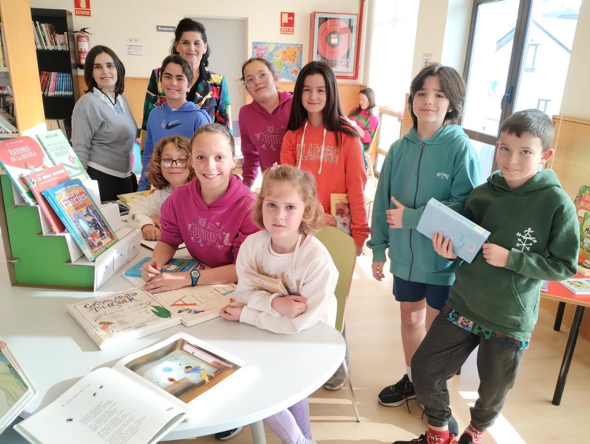 Un grupo de niños tapiegos en la actividad de la biblioteca, junto a la concejala de Cultura y la bibliotecaria.