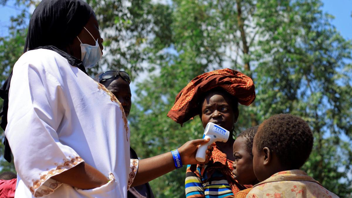 Un médico congoleño toma la temperatura a un niño antes de empezar la campaña de vacunación del Ébola en la población de Beni