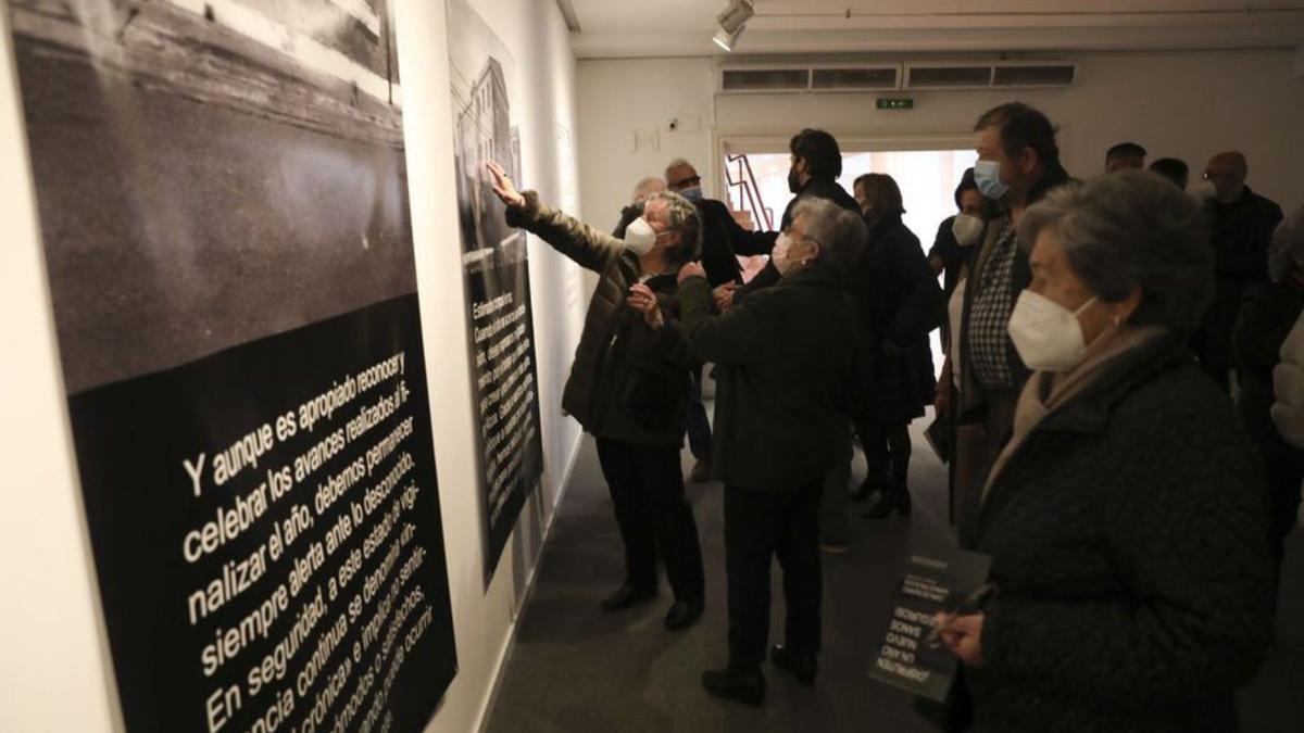 Público asistente a la inauguración ojea las fotos y los textos.