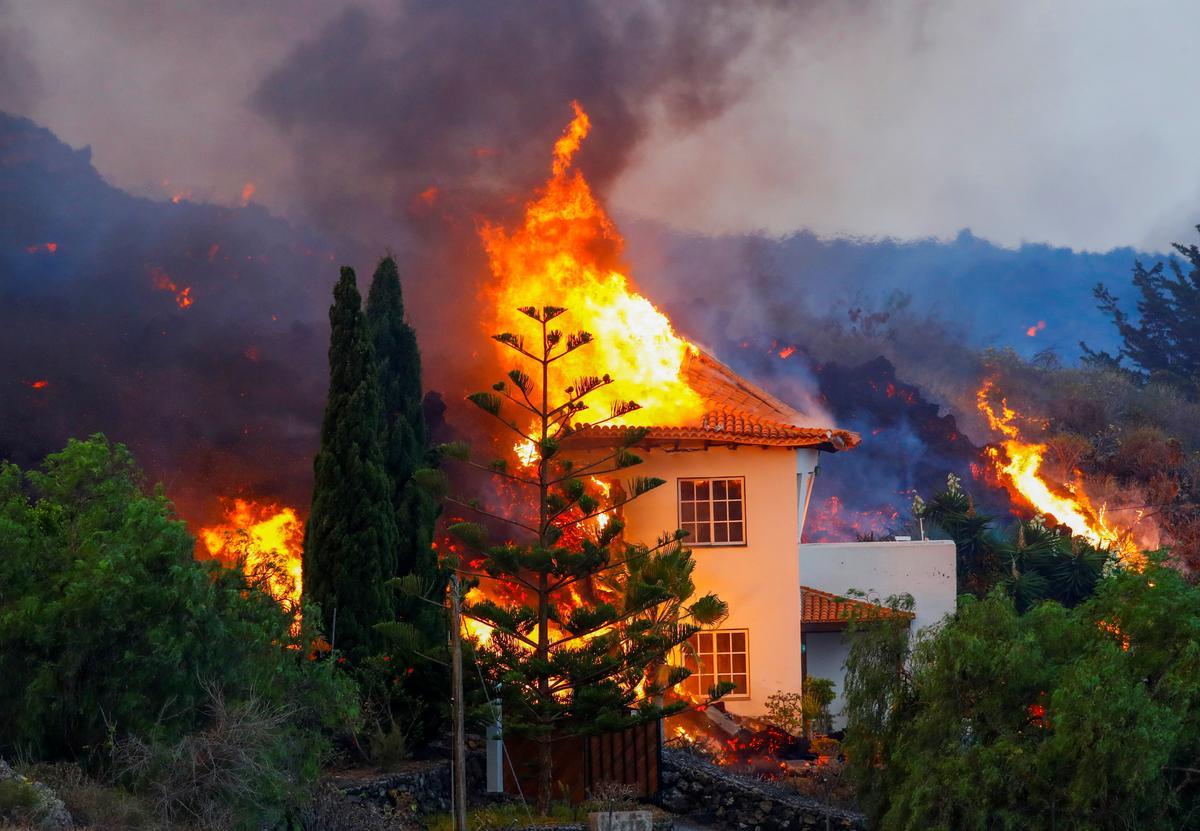 Una casa en llamas, tras la erupción del volcán en La Palma