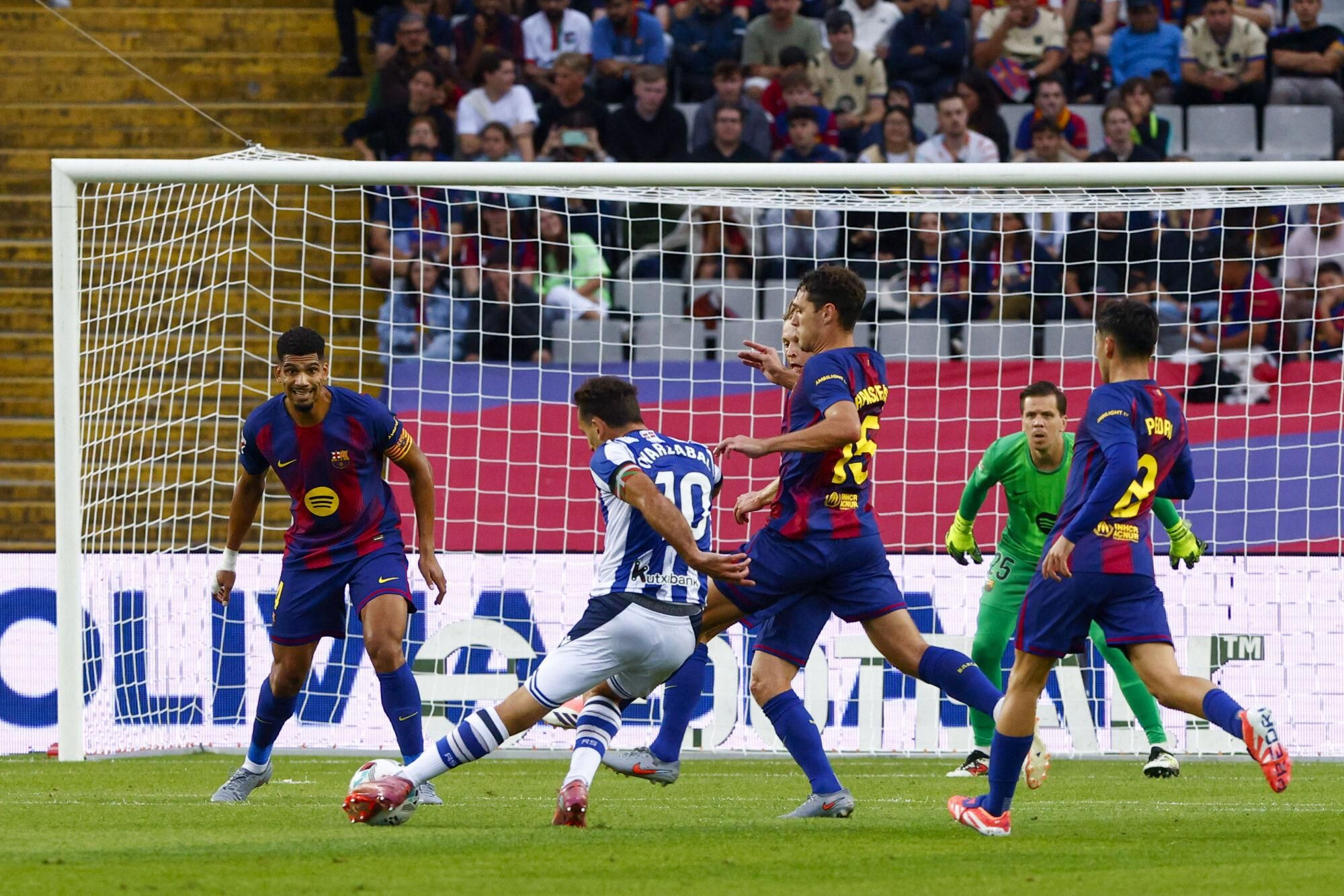 BARCELONA, 28/09/2025.- El delantero de la Real Sociedad, Mikel Oyarzabal (2i), remata ante el defensa danés del FC Barcelona, Andreas Christensen, durante el encuentro correspondiente a la séptima jornada de Liga EA Sports que FC Barcelona y Real Sociedad disputan este domingo en el estadio de Montjuic, en Barcelona. EFE/Quique García.