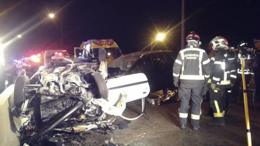 Bomberos junto a uno de los coches accidentados.